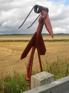 A bird sculpture on a path side fence